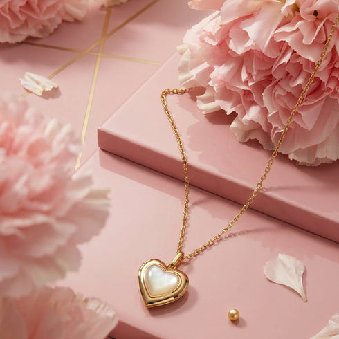 Gold necklace with a heart-shaped pendant on a pink surface with flowers