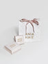 Ania Haie jewelry packaging with a marble bag and box on a light gray background